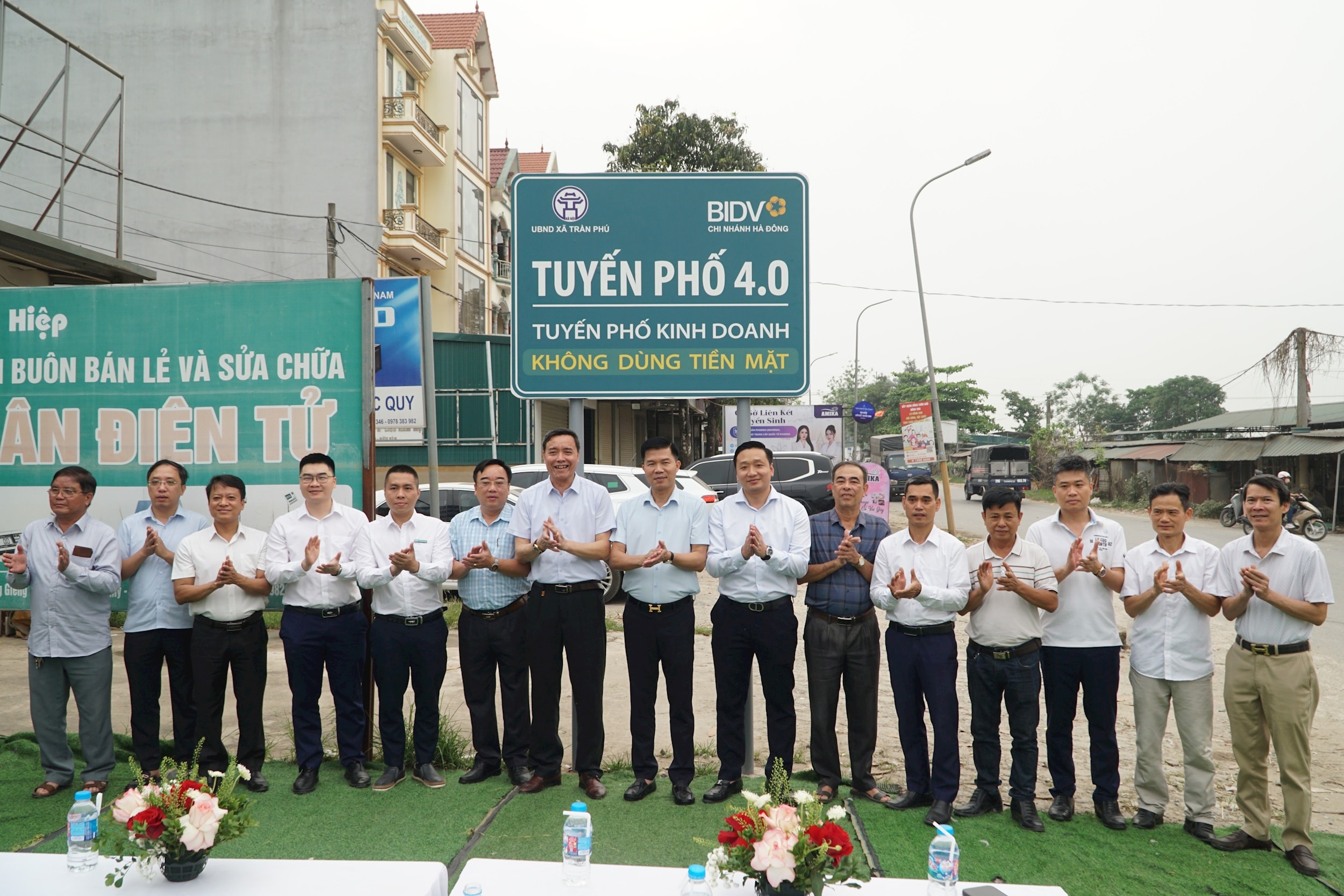 Các đồng chí lãnh đạo xã và đại biểu thực hiện nghi thức ra mắt tuyến phố 4.0, tuyến phố kinh doanh không dùng tiền mặt. Ảnh: Minh Khiêm.