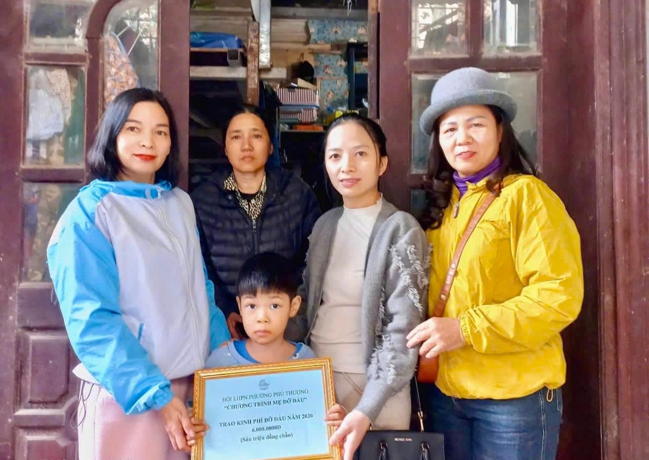 Chủ tịch Hội LHPN phường Phú Thượng Đỗ Thị Phương Lân (ngoài cùng bên trái) trao kinh phí hỗ trợ cho mẹ con chị Nguyễn Thị Luận. Ảnh: PT