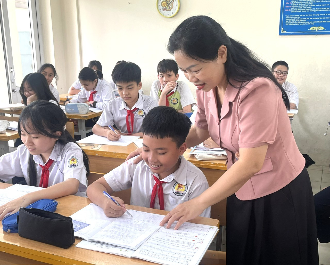 Cô Nguyễn Thị Ngọc Lan, giáo viên trường THCS Chu Văn An, phường Thanh Liệt hướng dẫn các học sinh hệ thống lại kiến thức trọng tâm để chuẩn bị cho kỳ thi. Ảnh: Kim Xuyến