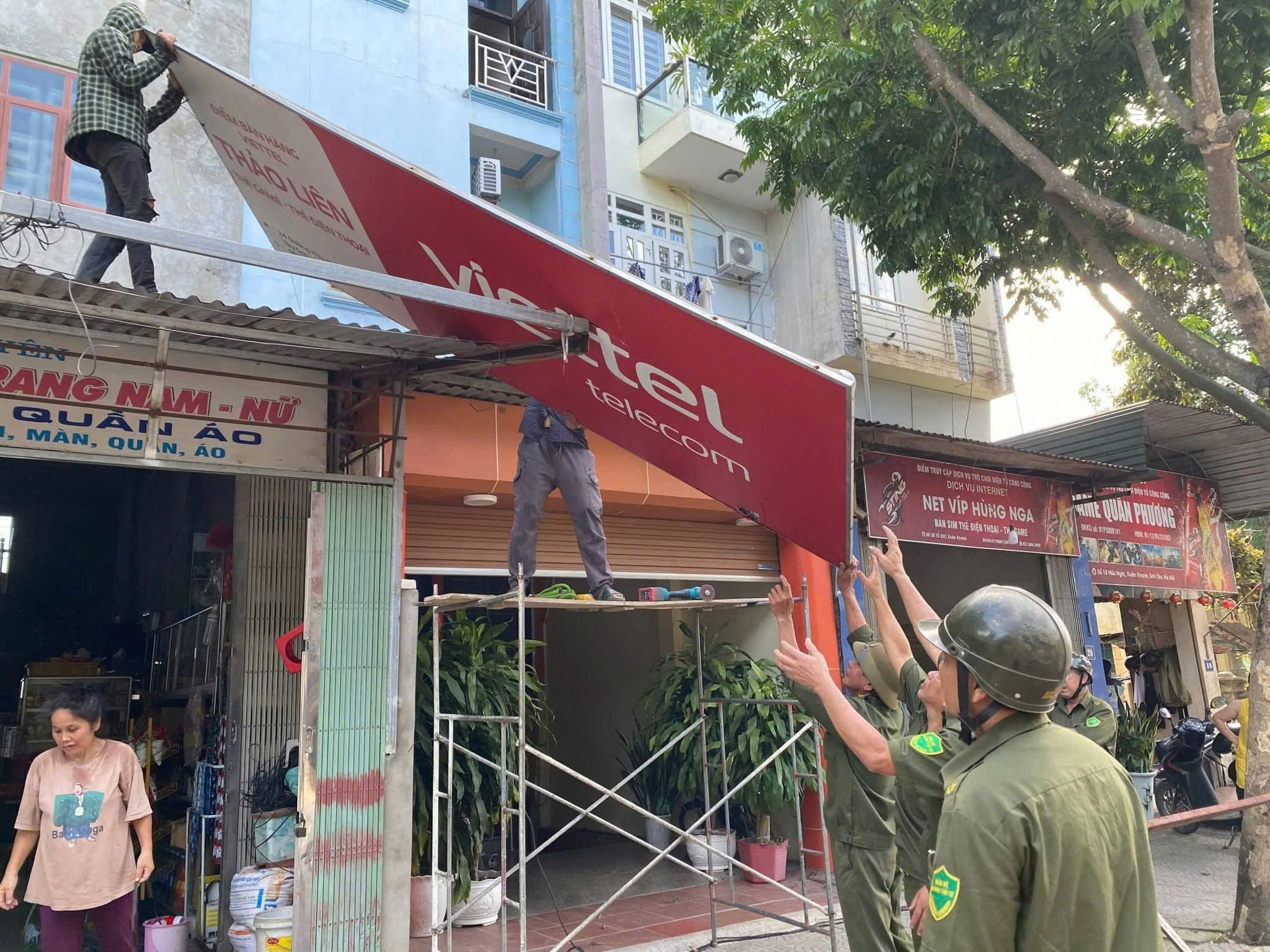 Clực lượng chức năng tổ chức tháo dỡ mái che, biển quảng cáo lấn chiếm vỉa hè trên địa bàn phường Tùng Thiện.