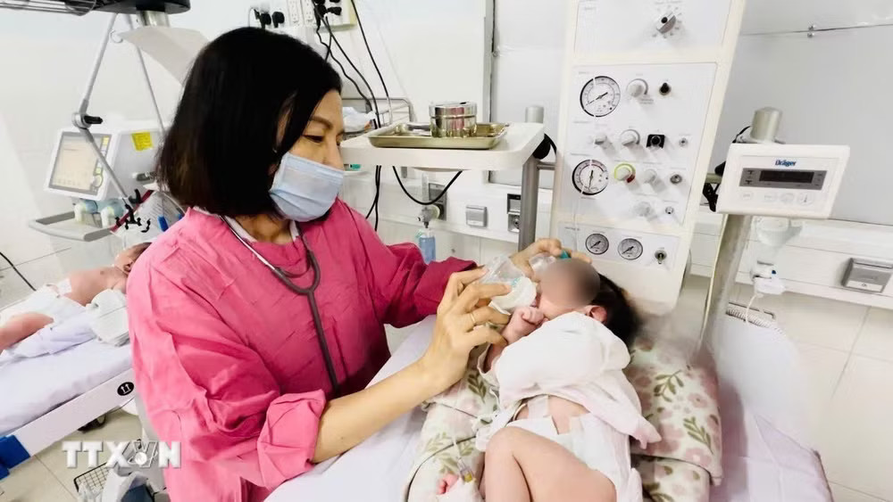 Mẹ và bé trai sơ sinh sau phẫu thuật trong phòng Hồi sức sơ sinh, Bệnh viện Đa khoa tỉnh Khánh Hòa. (Ảnh: TTXVN phát) ttxvn-tre-so-sinh.jpg