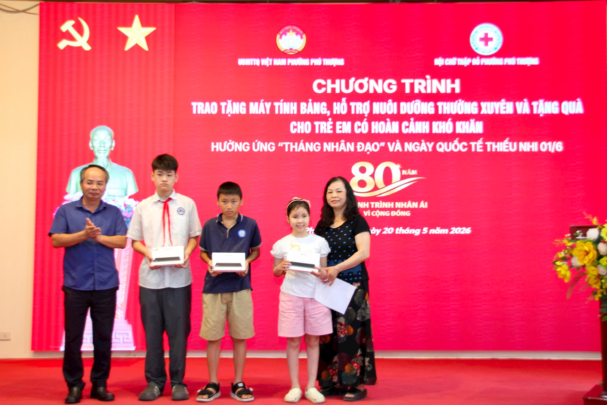 Chủ tịch Hội Chữ thập đỏ thành phố Hà Nội Lê Tự Lực trao tặng máy tính bảng hỗ trợ việc học tập cho 3 em học sinh ởphường Phú Thượng. Ảnh: PV