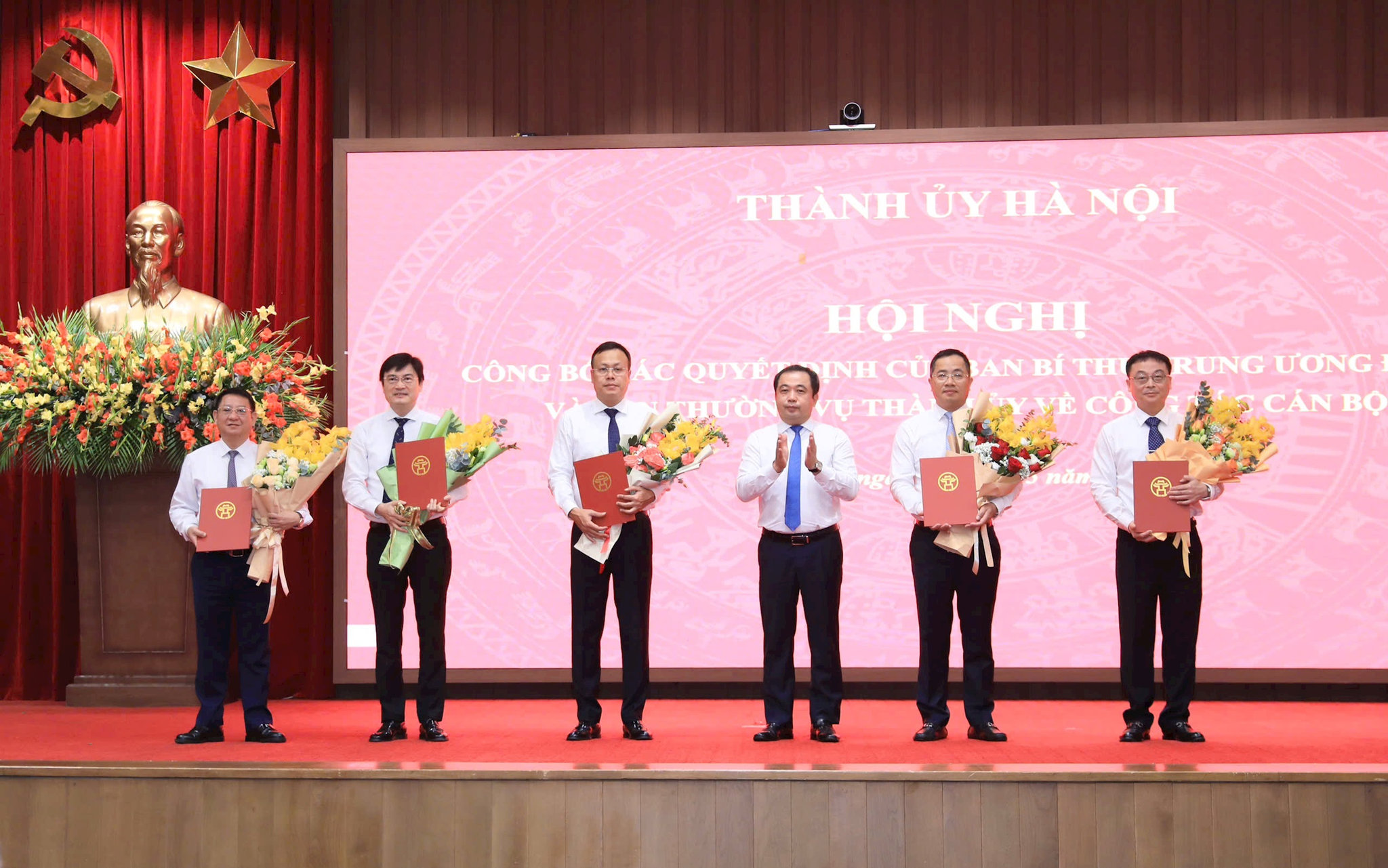 Bí thư Thành ủy Hà Nội Trần Đức Thắng trao quyết định của Ban Bí thư Trung ương Đảng về công tác cán bộ và tặng hoa chúc mừng các đồng chí nhận n