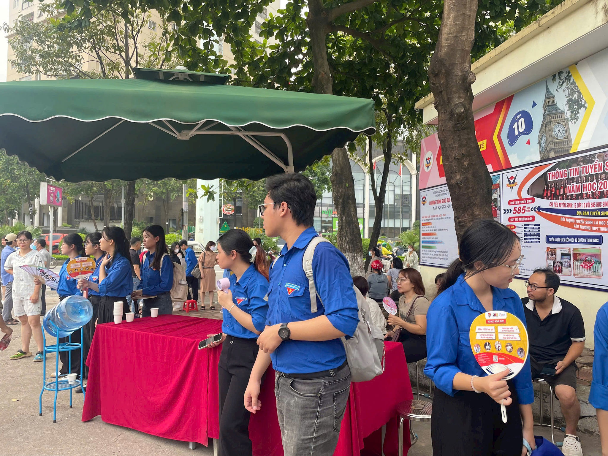Các trạm hỗ trợ nước uống, quạt mát miễn phí đã được lực lượng tình nguyện viên sắp xếp chu đáo ngay phía ngoài cổng trường để phục vụ thí sinh.