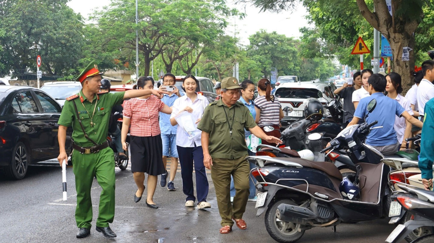 Cán bộ cảnh sát hướng dẫn, nhắc nhở giữ gìn an ninh trật tự xung quanh khu vực thi