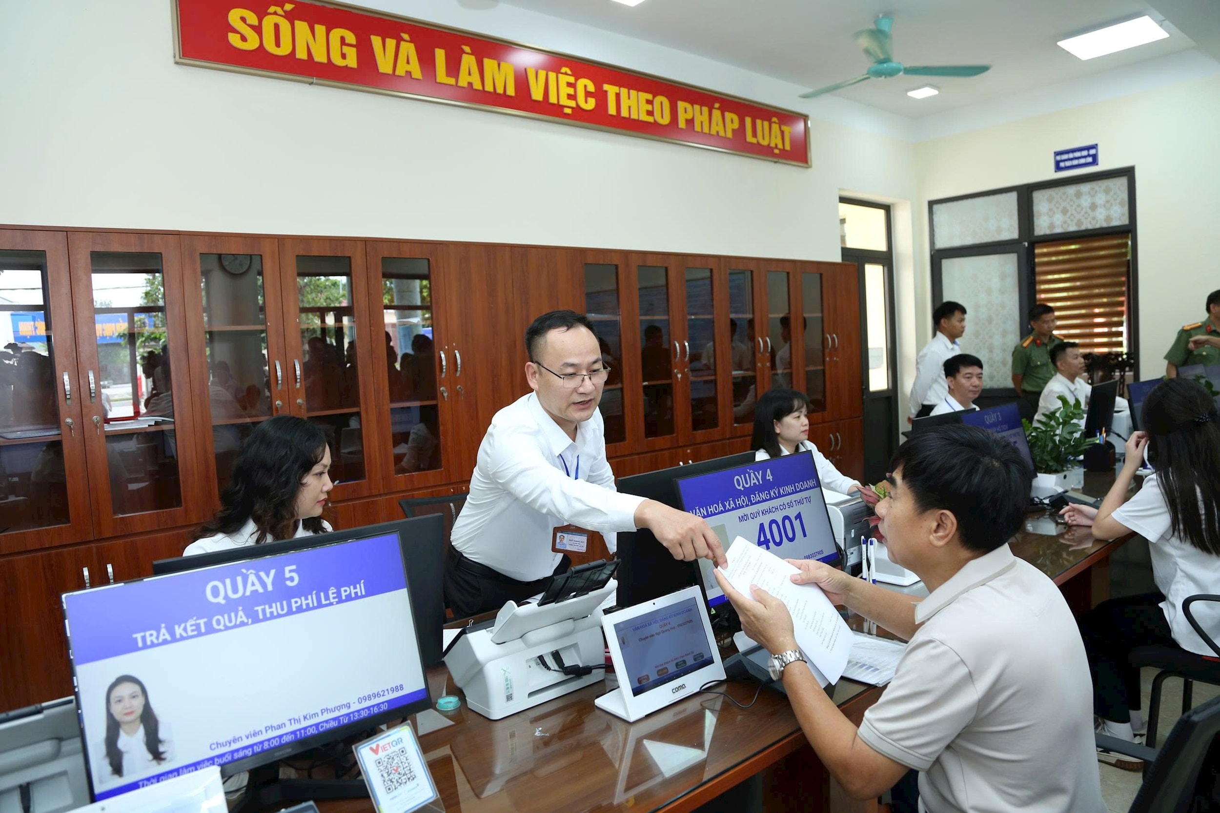 Cán bộ hướng dẫn người dân làm thủ tục hành chính tại xã Phúc Thịnh, Hà Nội. Ảnh Phạm Hùng