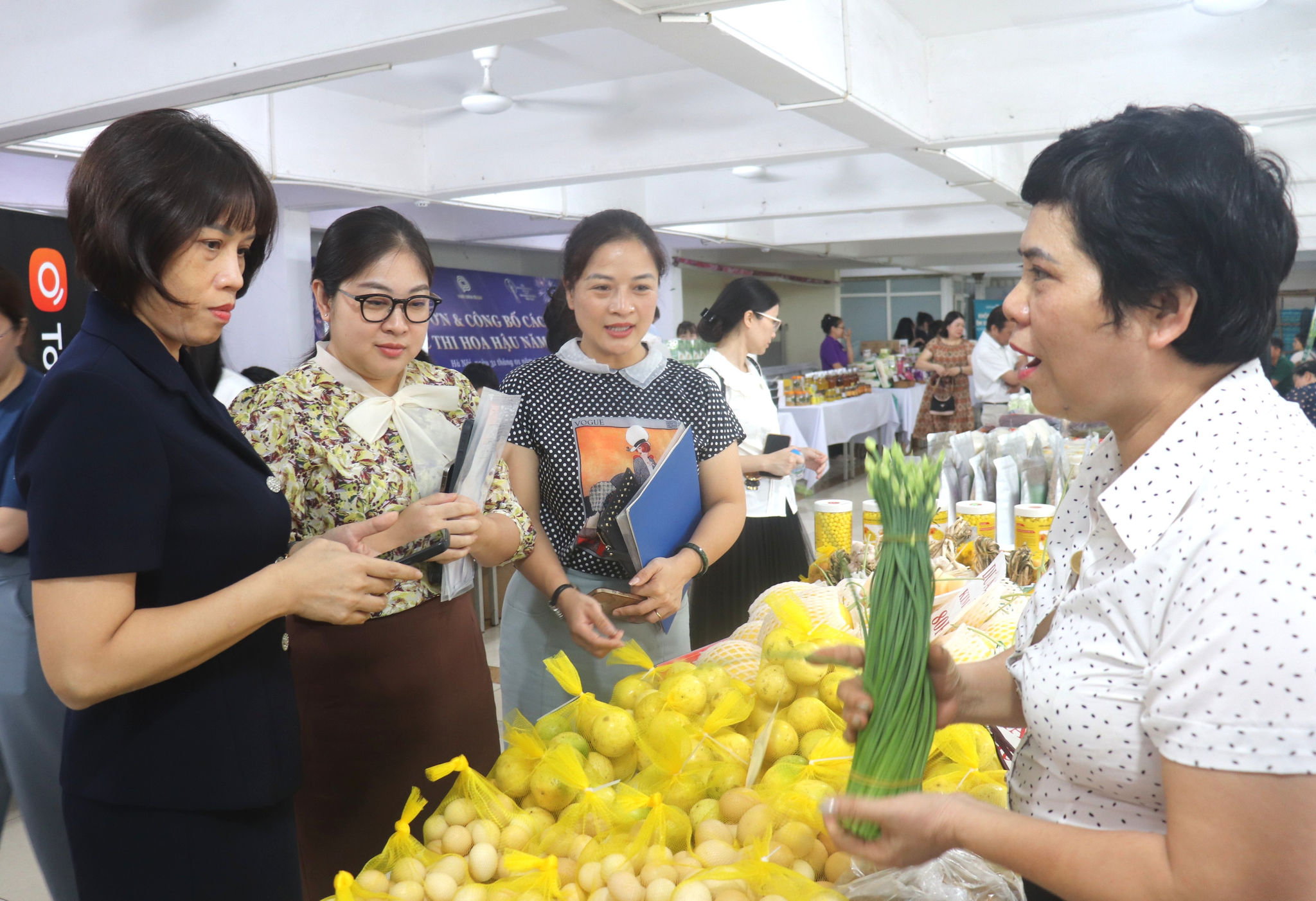 Phó Bí thư Đảng ủy, Chủ tịch UBND phường Bạch Mai Nguyễn Thị Thu Hiền và đại biểu, người dân tìm hiểu sản phẩm hàng hóa của doanh nghiệp, hộ kinh doanh trên địa bàn. Ảnh: PV