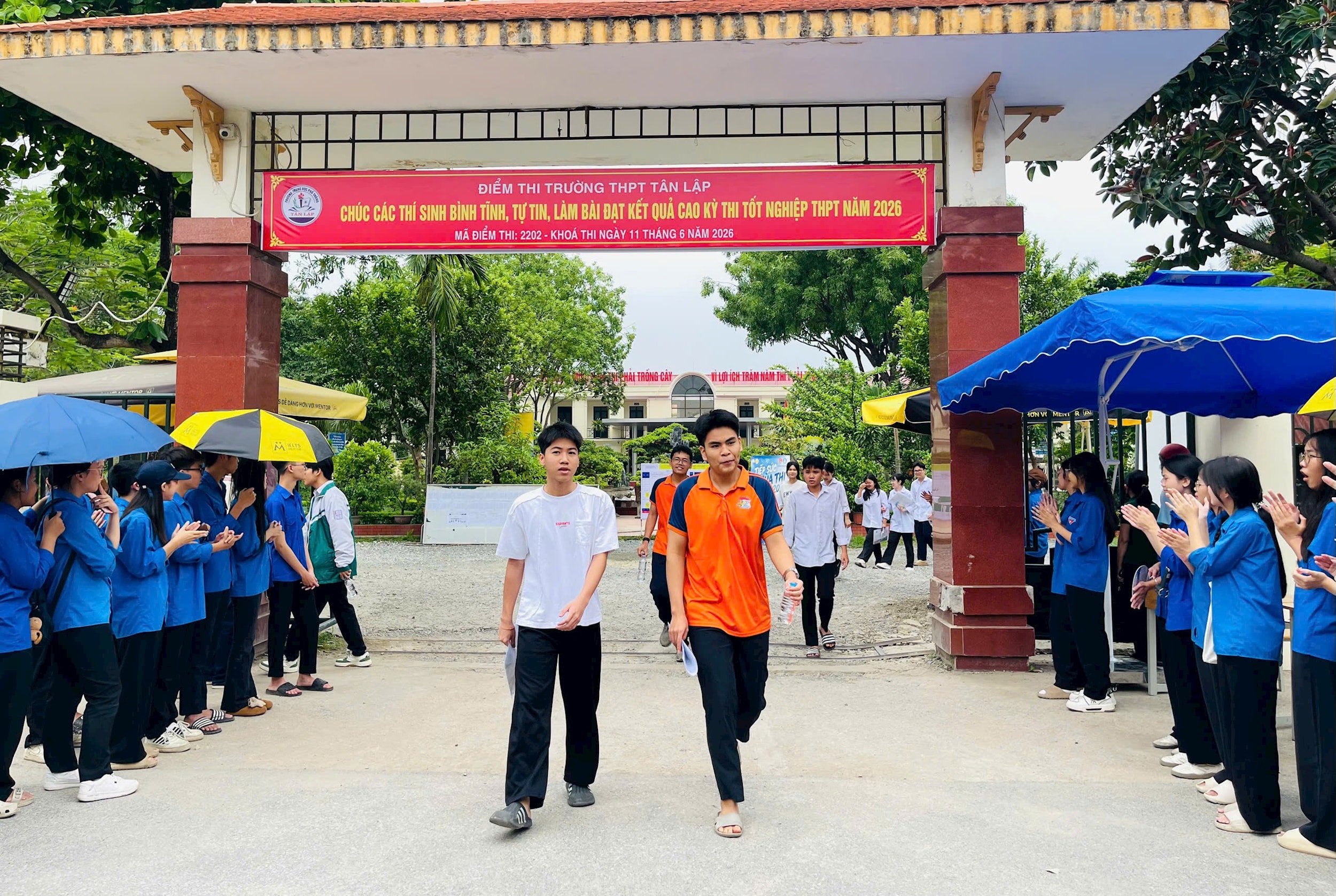 Những thí sinh đầu tiên rời phòng thi trong sự chào đón, cổ vũ nhiệt tình của lực lượng thanh niên tình nguyện tại điểm thi Trường THPT Tân Lập. Ảnh: Ánh Bình