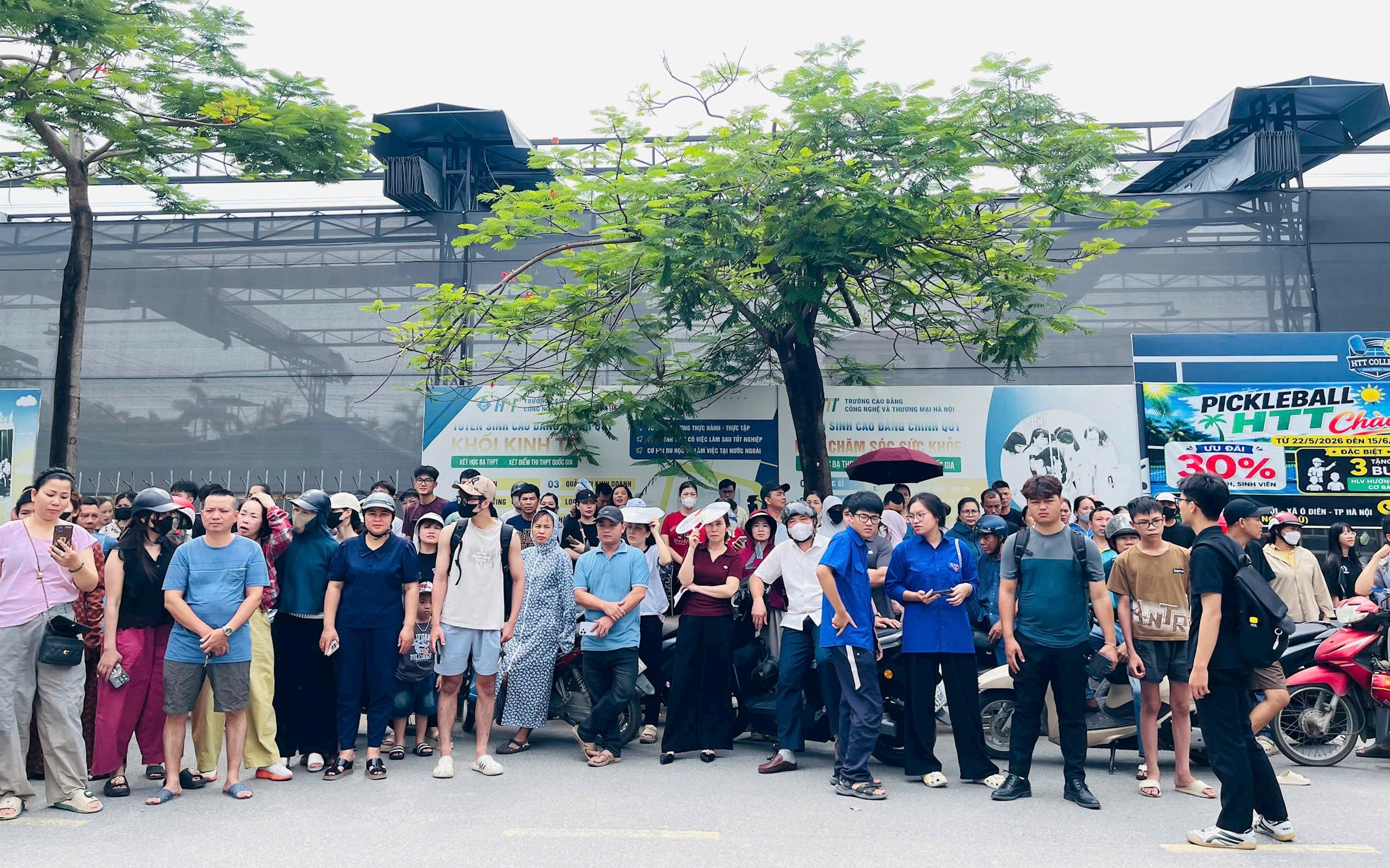 Đông đảo phụ huynh tập trung bên ngoài điểm thi, dõi theo và chờ đợi con em hoàn thành bài thi trong kỳ thi tốt nghiệp THPT năm 2026. Ảnh: Ánh Bình