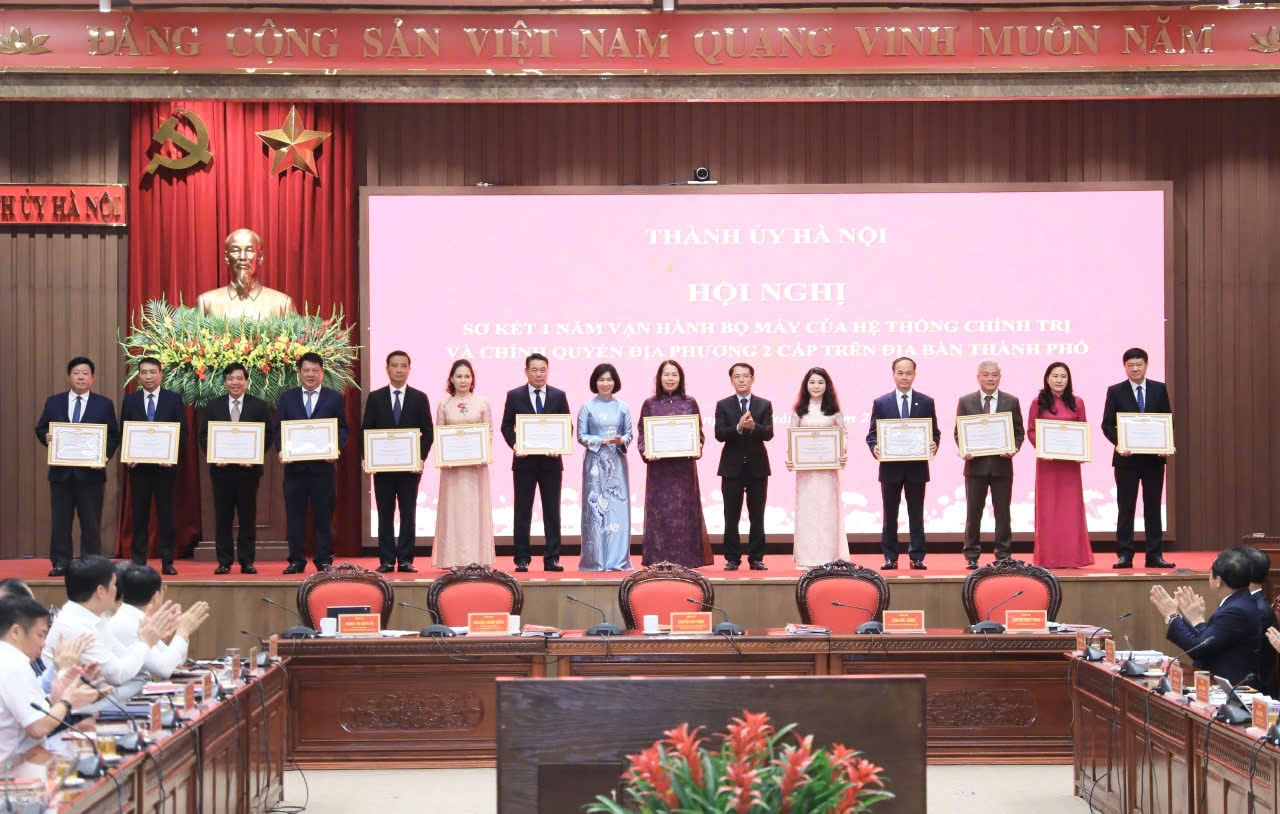 Chủ tịch UBND phường Từ Liêm Nguyễn Thanh Bình (đứng thứ hai từ trái qua) thay mặt Đảng bộ, chính quyền, nhân dân phường nhận Bằng khen của Ban Thường vụ Thành uỷ Hà Nội vì có thành tích xuất sắc trong một năm vận hành bộ máy của hệ thống chính trị và chính quyền địa phương hai cấp. Ảnh: PV