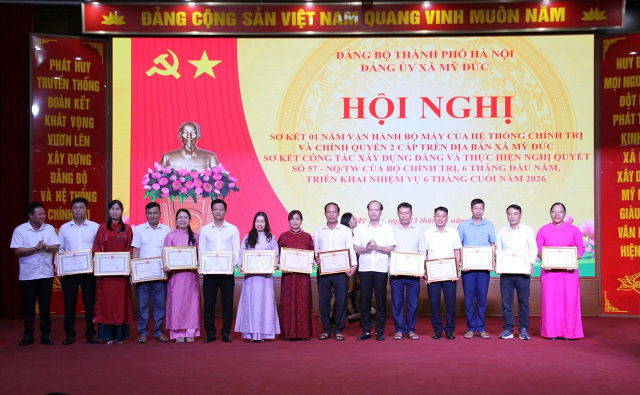 :L&atilde;nh đạo x&atilde; Mỹ Đức trao Giấy khen của Chủ tịch UBND x&atilde; cho c&aacute;c tập thể c&oacute; th&agrave;nh t&iacute;ch xuất sắc trong 1 năm vận h&agrave;nh m&ocirc; h&igrave;nh ch&iacute;nh quyền địa phương hai cấp. Ảnh: Bi&ecirc;n Phạm