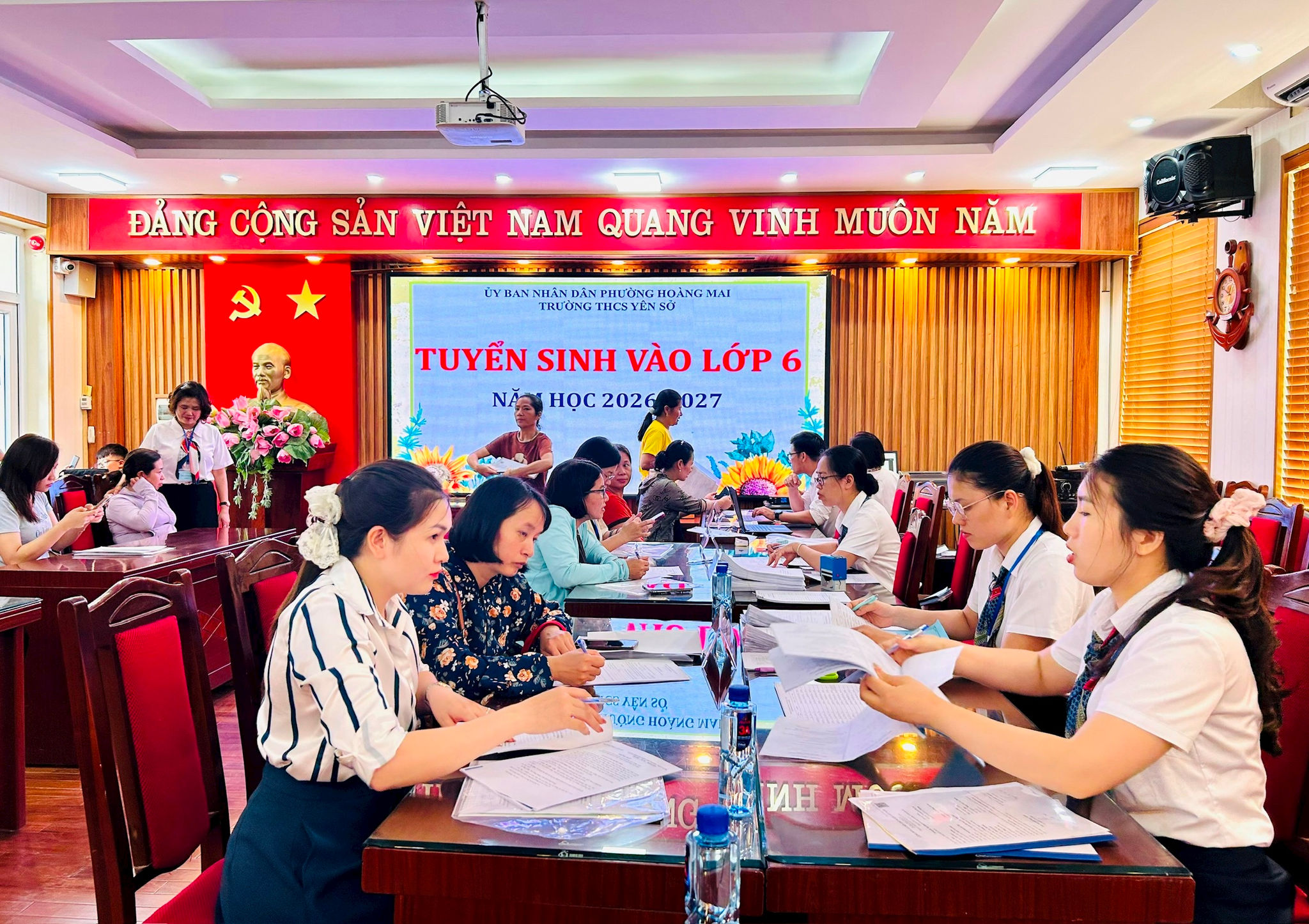 Phụ huynh được giáo viên Trường THCS Yên Sở hỗ trợ đăng ký trực tuyến ngay tại trường. Ảnh: Trần Oanh