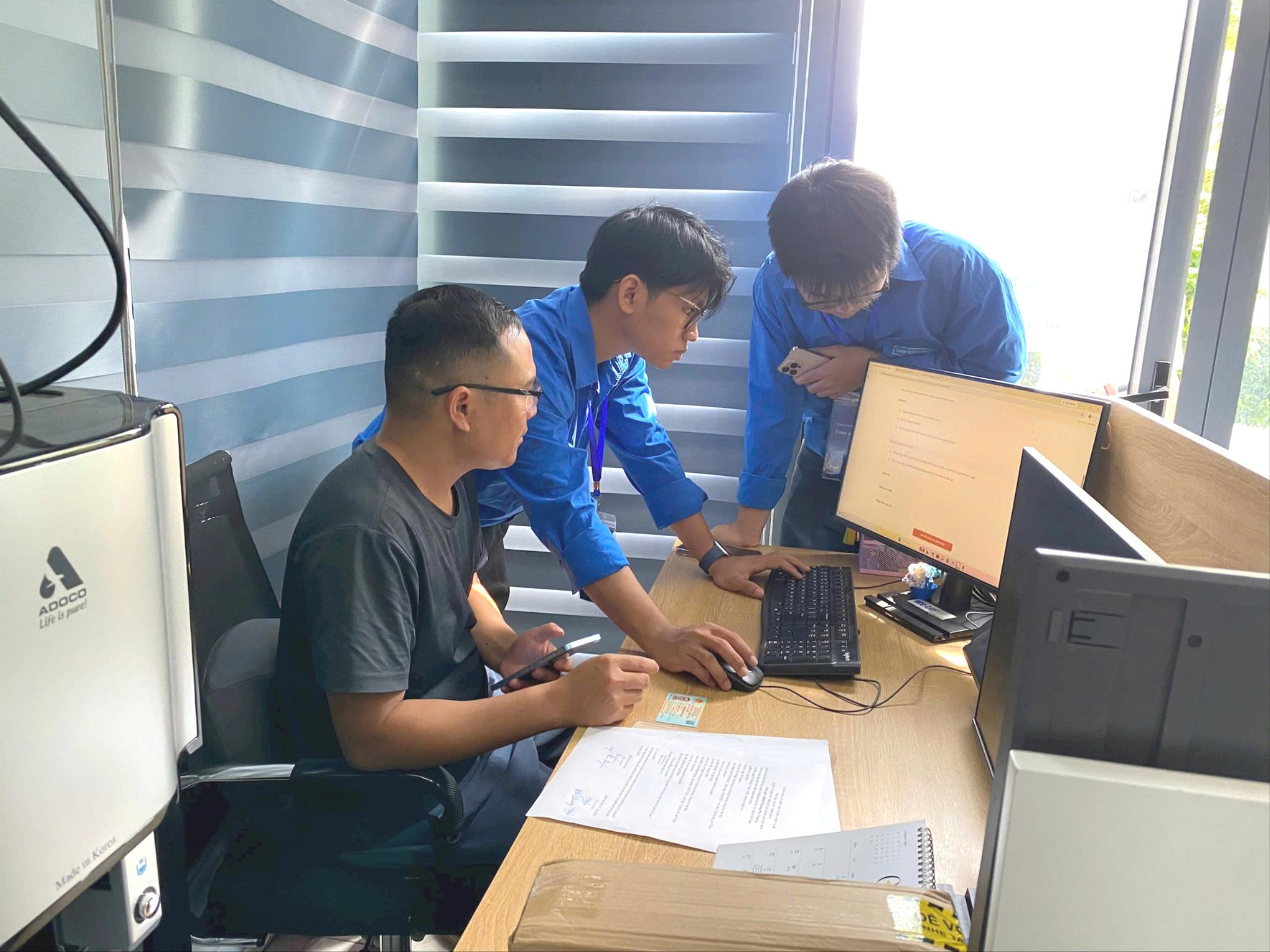 Tuổi trẻ phường Phú Thượng hỗ trợ người dân tham gia khảo sát, đánh giá chất lượng dịch vụ hành chính công. Ảnh: PT