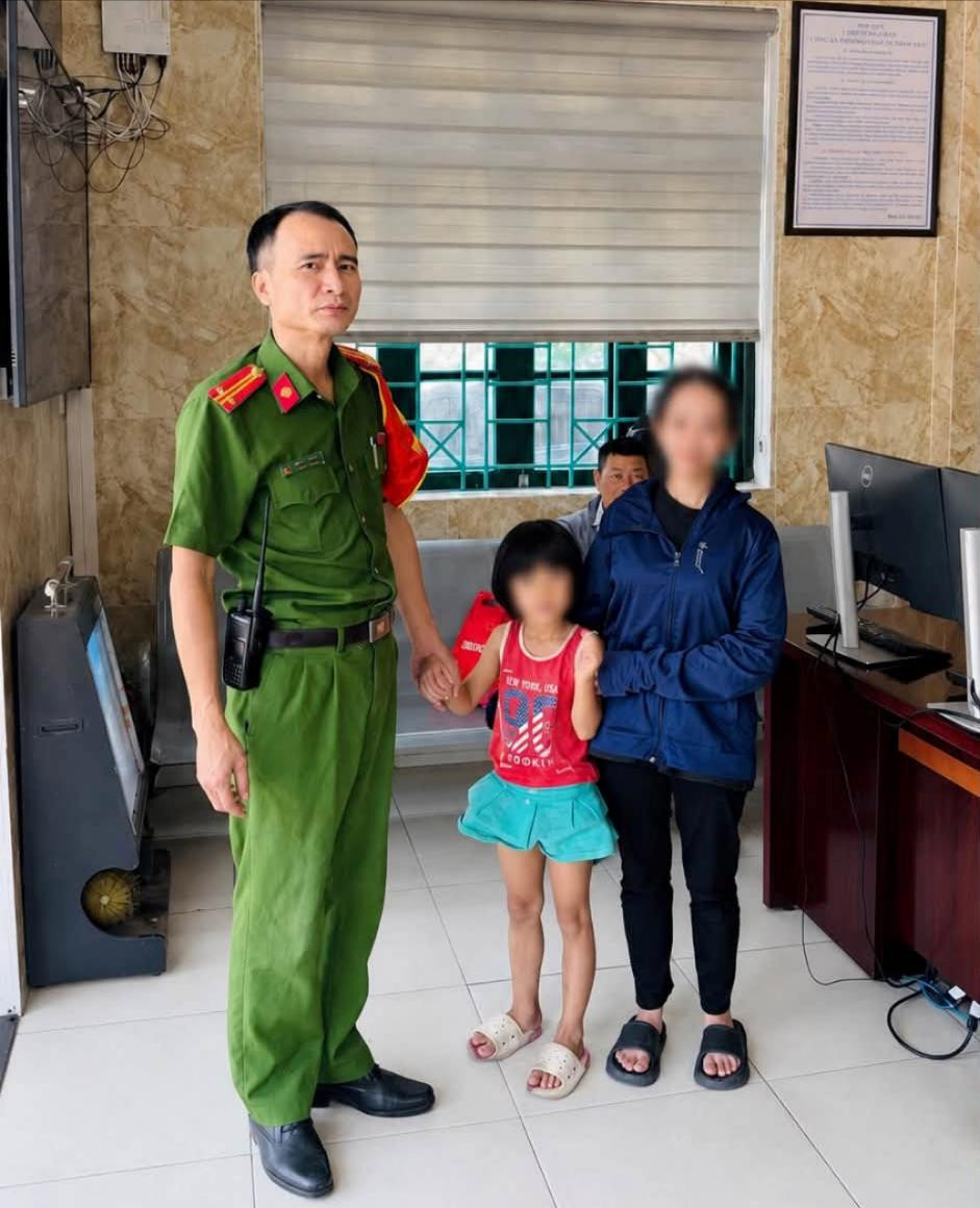 Công an phường Phú Thượng bàn giao cháu bé an toàn cho người thân. Ảnh: PT