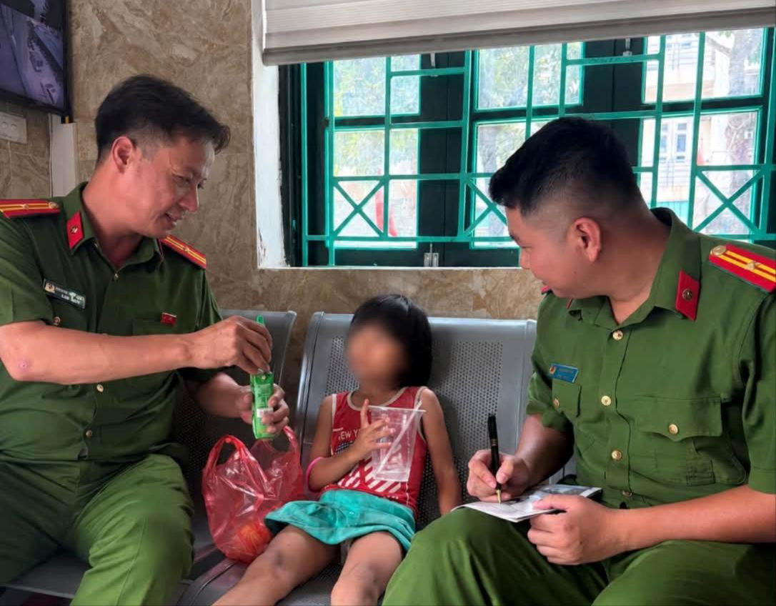 Công an phường Phú Thượng chăm sóc cháu bé trong quá trình xác minh, liên hệ gia đình. Ảnh: PT