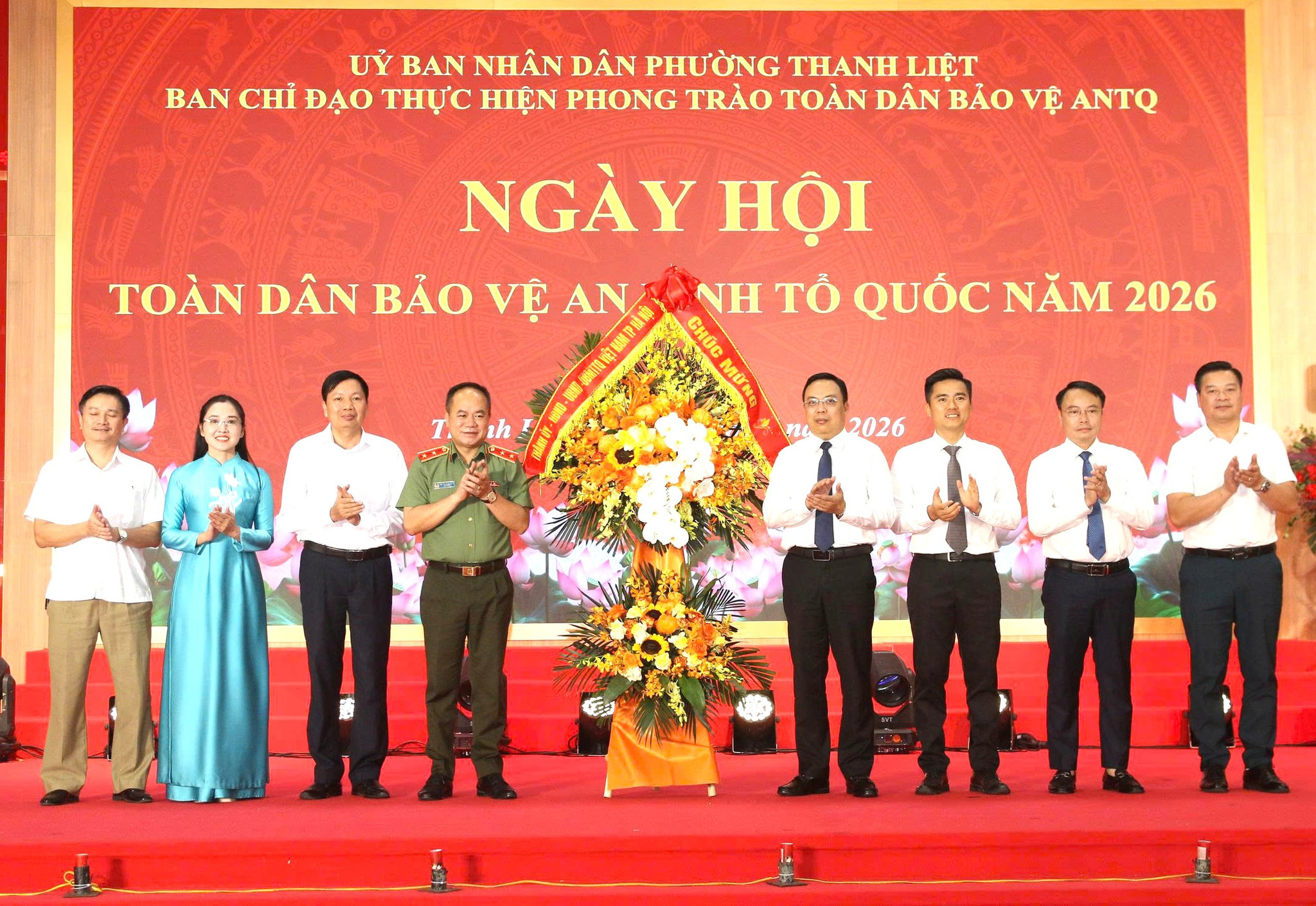 Trung tướng Nguyễn Thanh Tùng đại diện tặng hoa chúc mừng cho UBND phường Thanh Liệt. Ảnh: PV