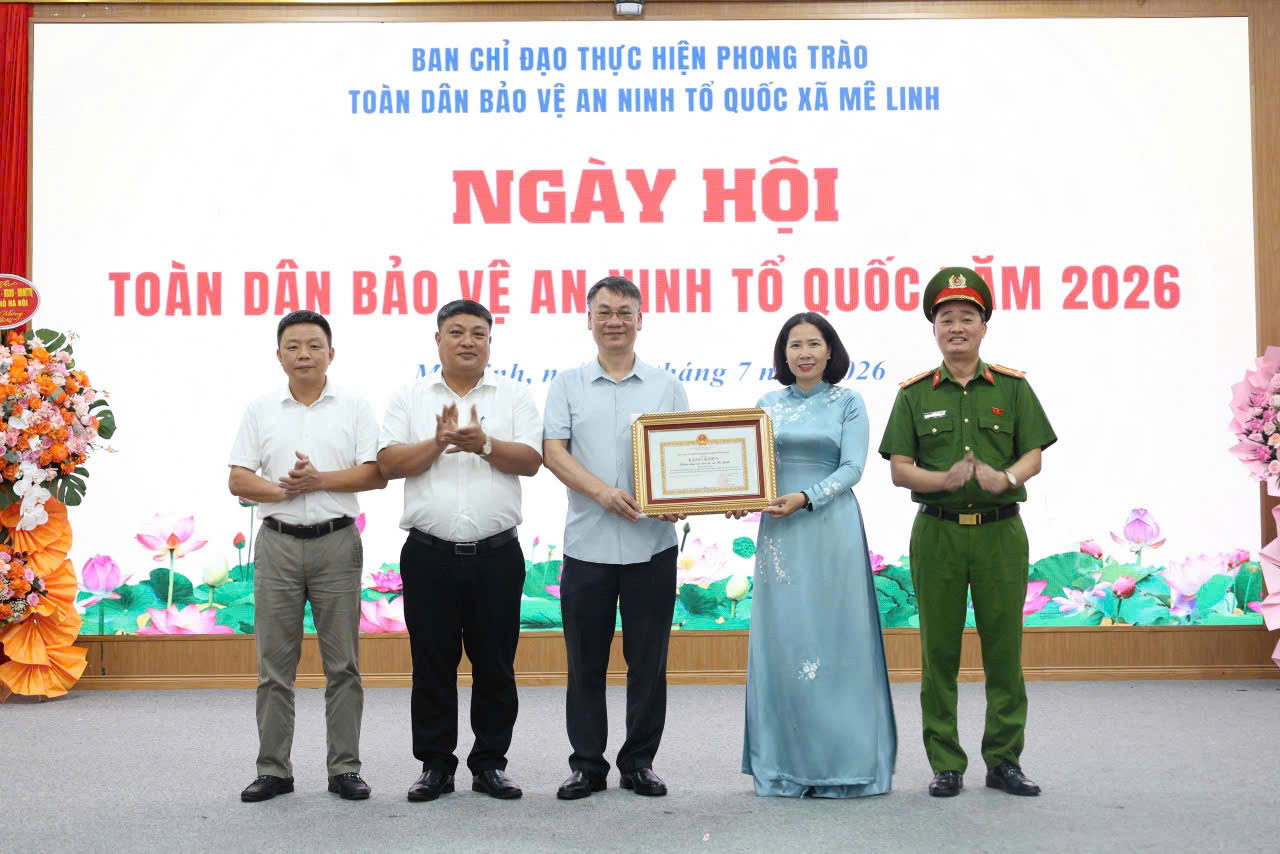 Thành ủy viên, Phó Chủ tịch Ủy ban MTTQ Việt Nam thành phố Hà Nội, Chủ tịch Hội LHPN thành phố Hà Nội Lê Kim Anh trao bằng khen của thành phố cho xã Mê Linh. Ảnh: PV