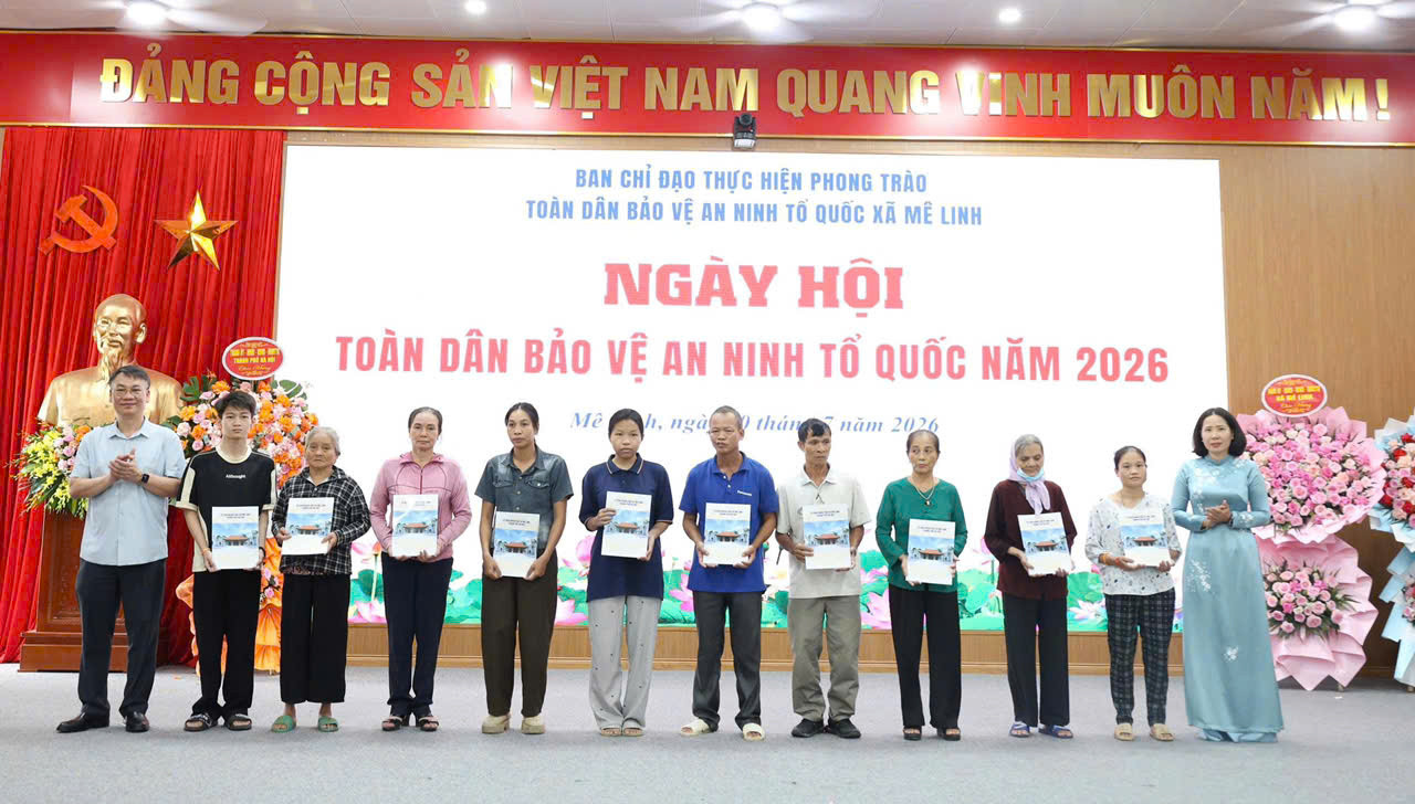 Các đồng chí lãnh đạo thành phố và lãnh đạo xã trao quà cho các gia đình có hoàn cảnh khó khăn. Ảnh: PV