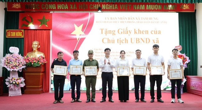 Phó Chủ tịch UBND xã Tam Hưng Nguyễn Thành Nam tặng giấy khen các tập thể, cá nhân trong phong trào Toàn dân bảo vệ an ninh Tổ quốc. Ảnh: PV