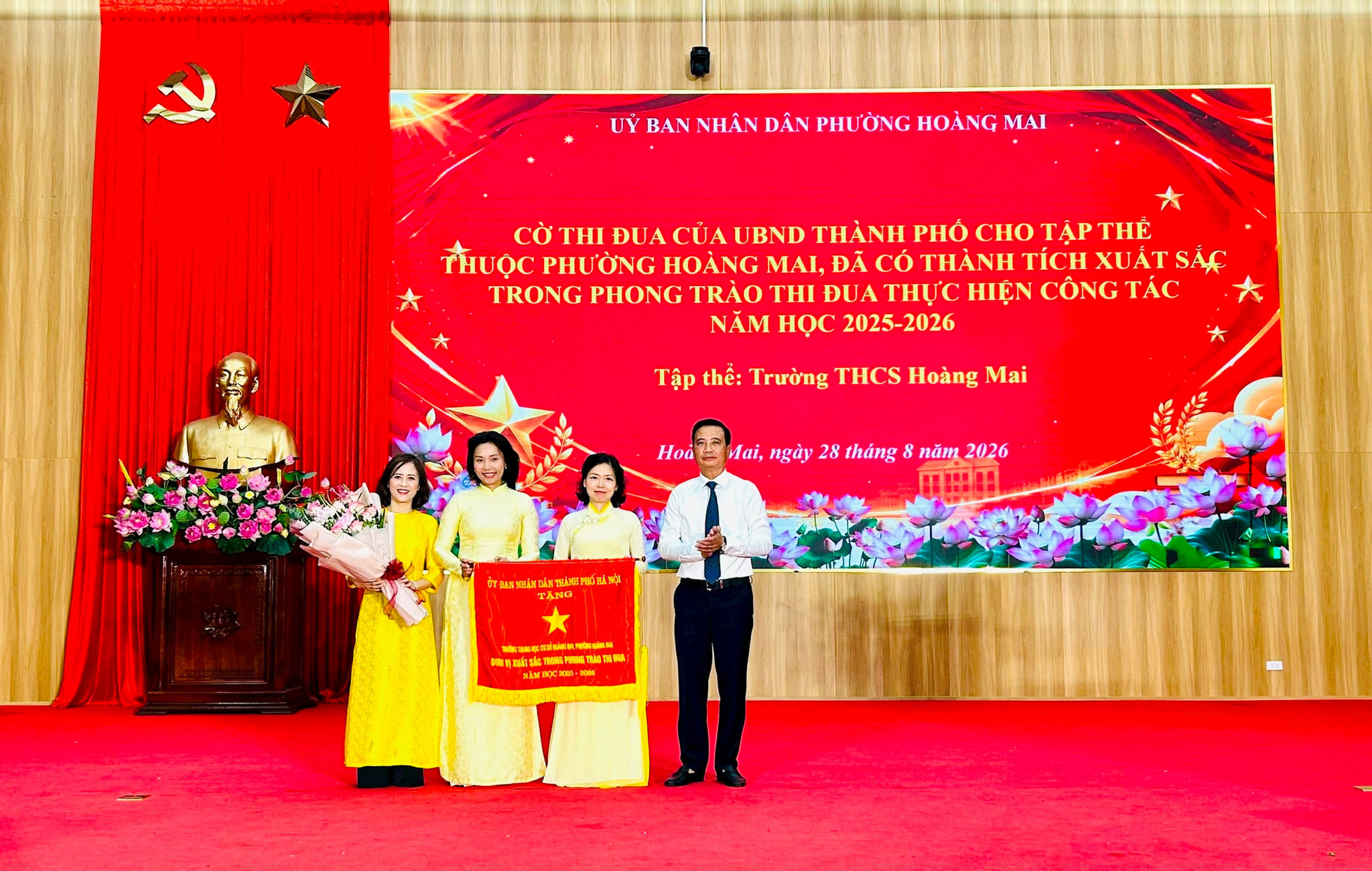 Bí thư Đảng ủy, Chủ tịch HĐND phường Hoàng Mai Nguyễn Xuân Linh trao Cờ thi đua của UBND Thành phố cho tập thể Trường THCS Hoàng Mai. Ảnh: Trần Oanh.