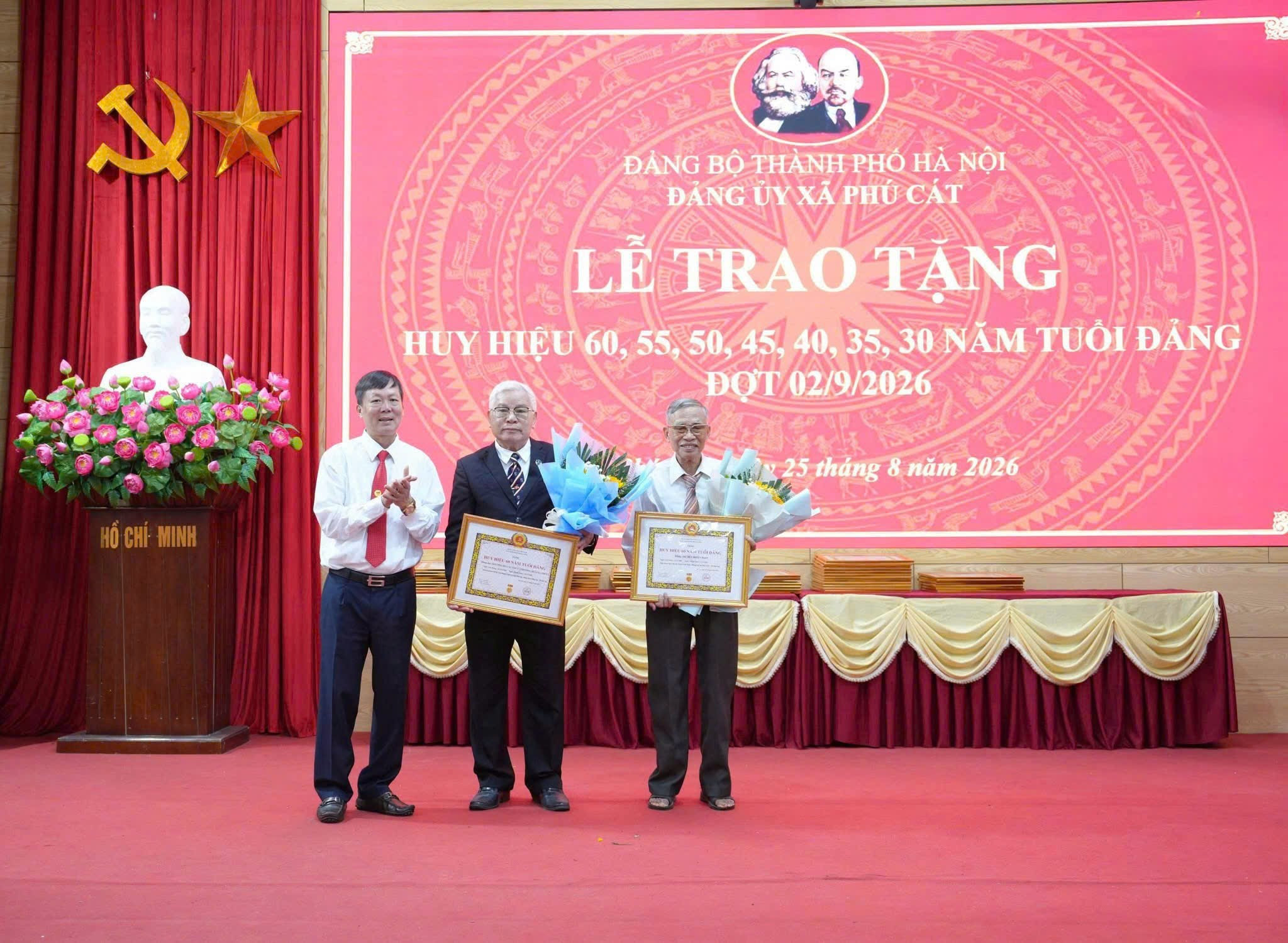 Đồng chí Đàm Công Lợi, Bí thư Đảng ủy, Chủ tịch HĐND xã trao Huy hiệu Đảng và tặng hoa chúc mừng các đảng viên. Ảnh: N.Hiệp