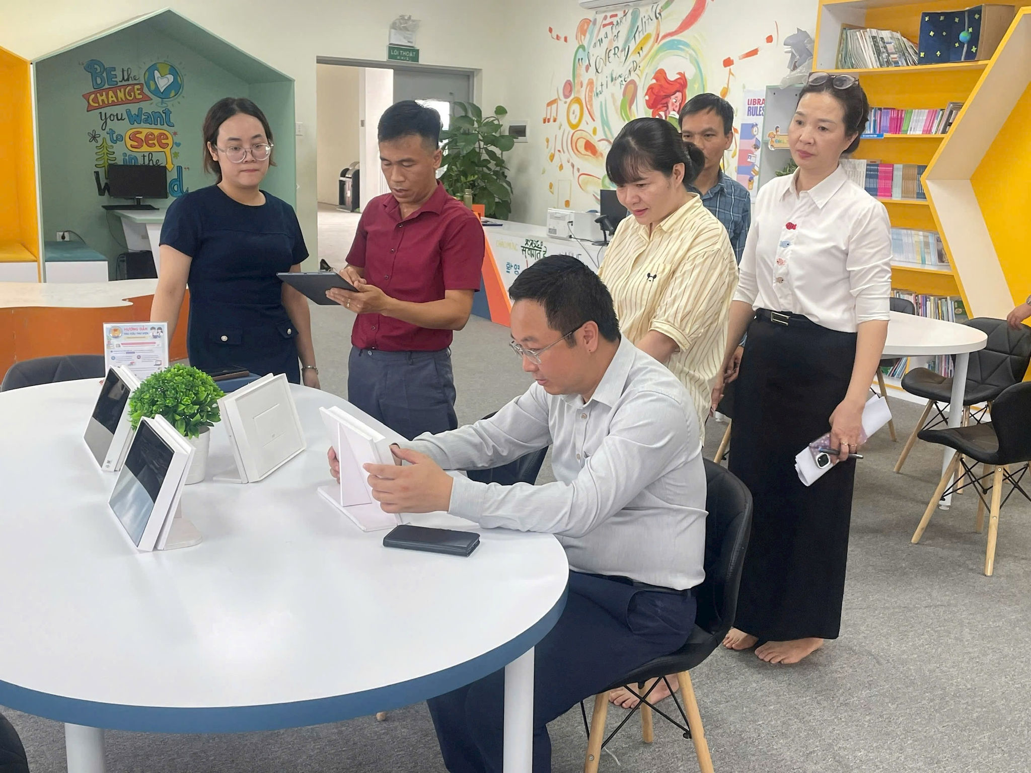 Lãnh đạo xã Gia Lâm trải nghiệm hệ thống thư viện số và thiết bị tra cứu thông minh tại trường THCS. Ảnh: Hoang