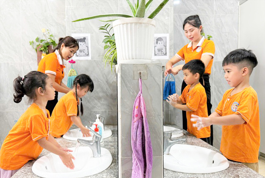 Giáo viên Trường Mầm non Tiến Thịnh, xã Yên Lãng hướng dẫn trẻ rửa tay với xà phòng. Ảnh: Đức Vân