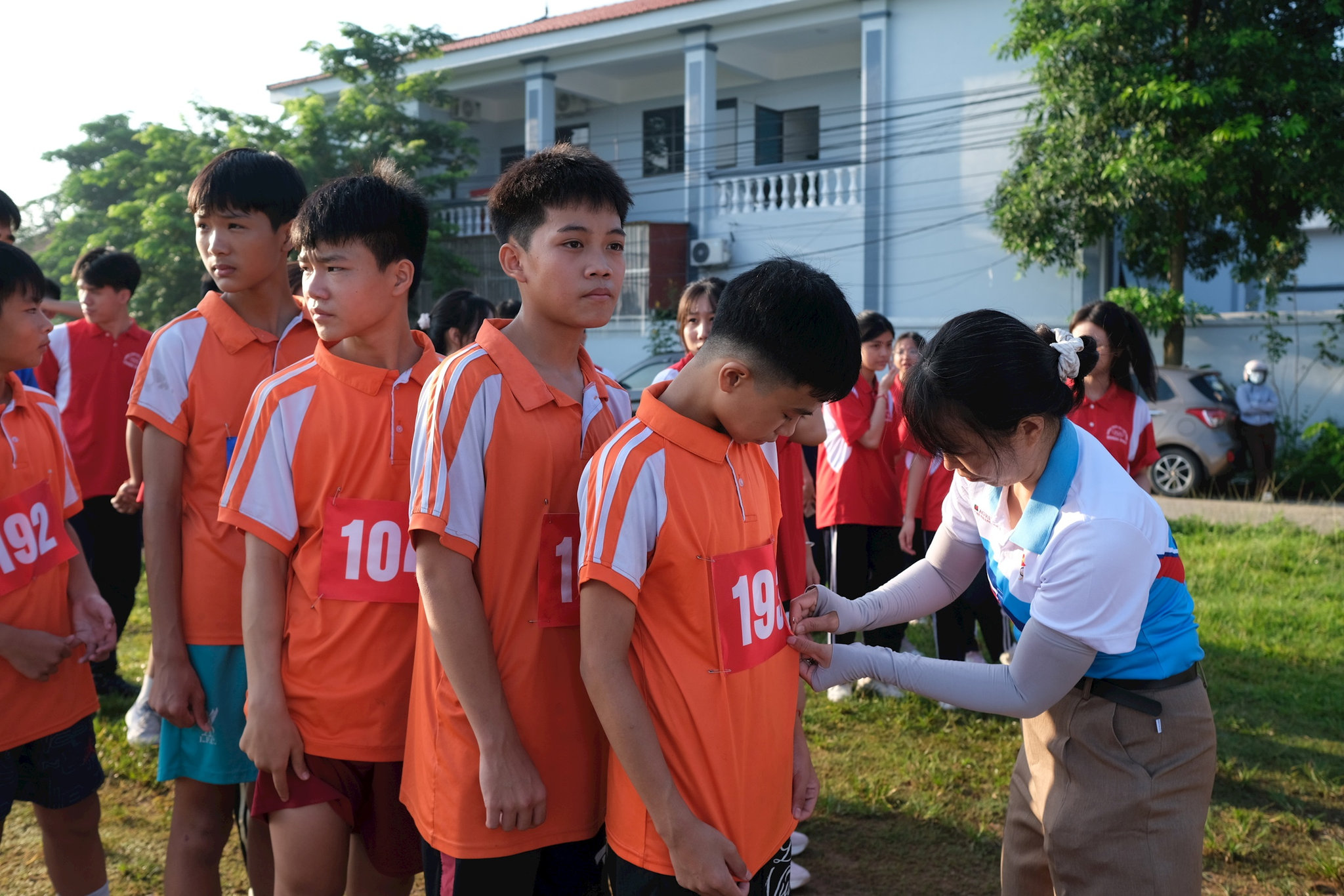 Trọng tài gắn số cho các học sinh trường Tiểu học và THCS Tân Dân trước khi bước vào thi đấu. Ảnh: Sỹ Ha