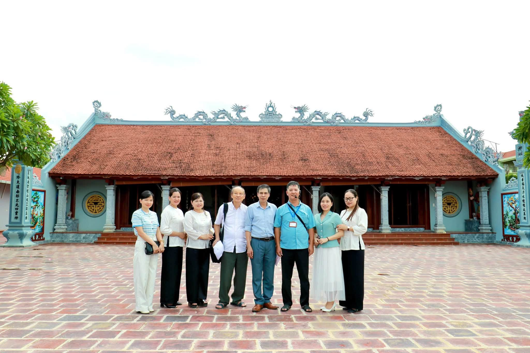 Các đại biểu chụp ảnh lưu niệm trước đình Vân La. Ảnh: Xuân Hòa.