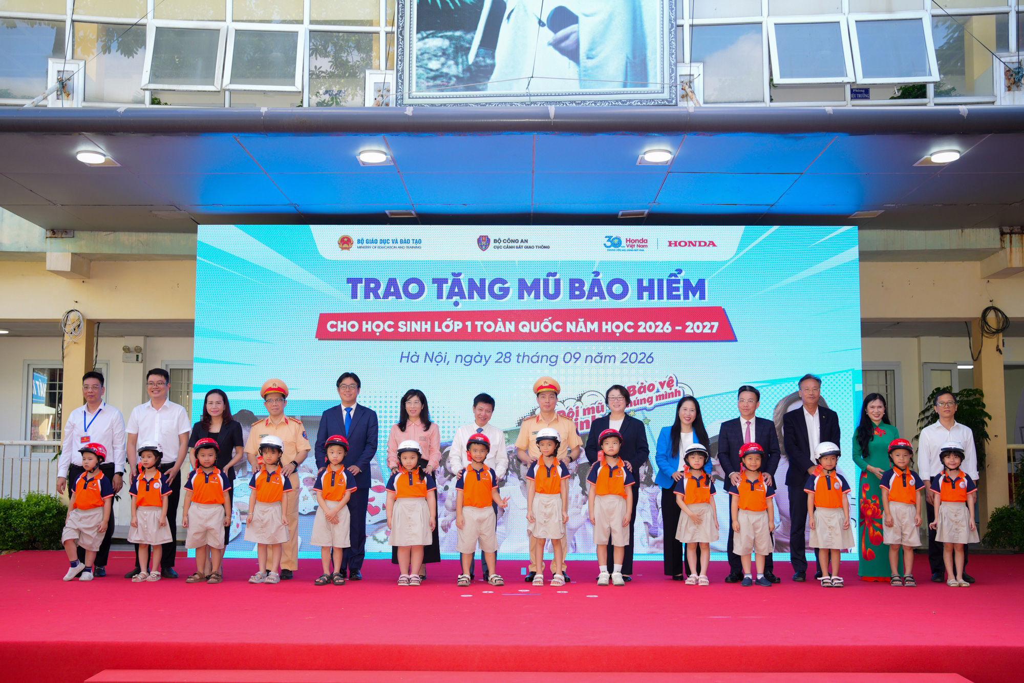 7.2.-cac-dai-bieu-trao-tang-mu-bao-hiem-cho-cac-em-hoc-sinh-lop-mot-truong-tieu-hoc-ngoc-lam.jpg