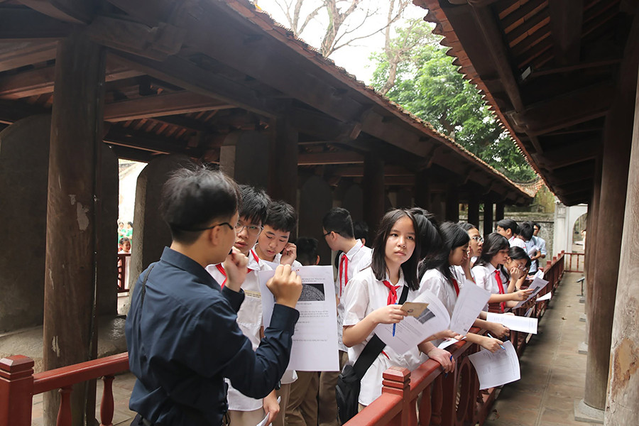 Học sinh Trường THCS Khương Thượng (Hà Nội) nghe thuyết minh về lịch sử, giá trị của các văn bia Tiến sĩ. Ảnh: Trung tâm VHKH Văn Miếu - Quốc Tử Giám