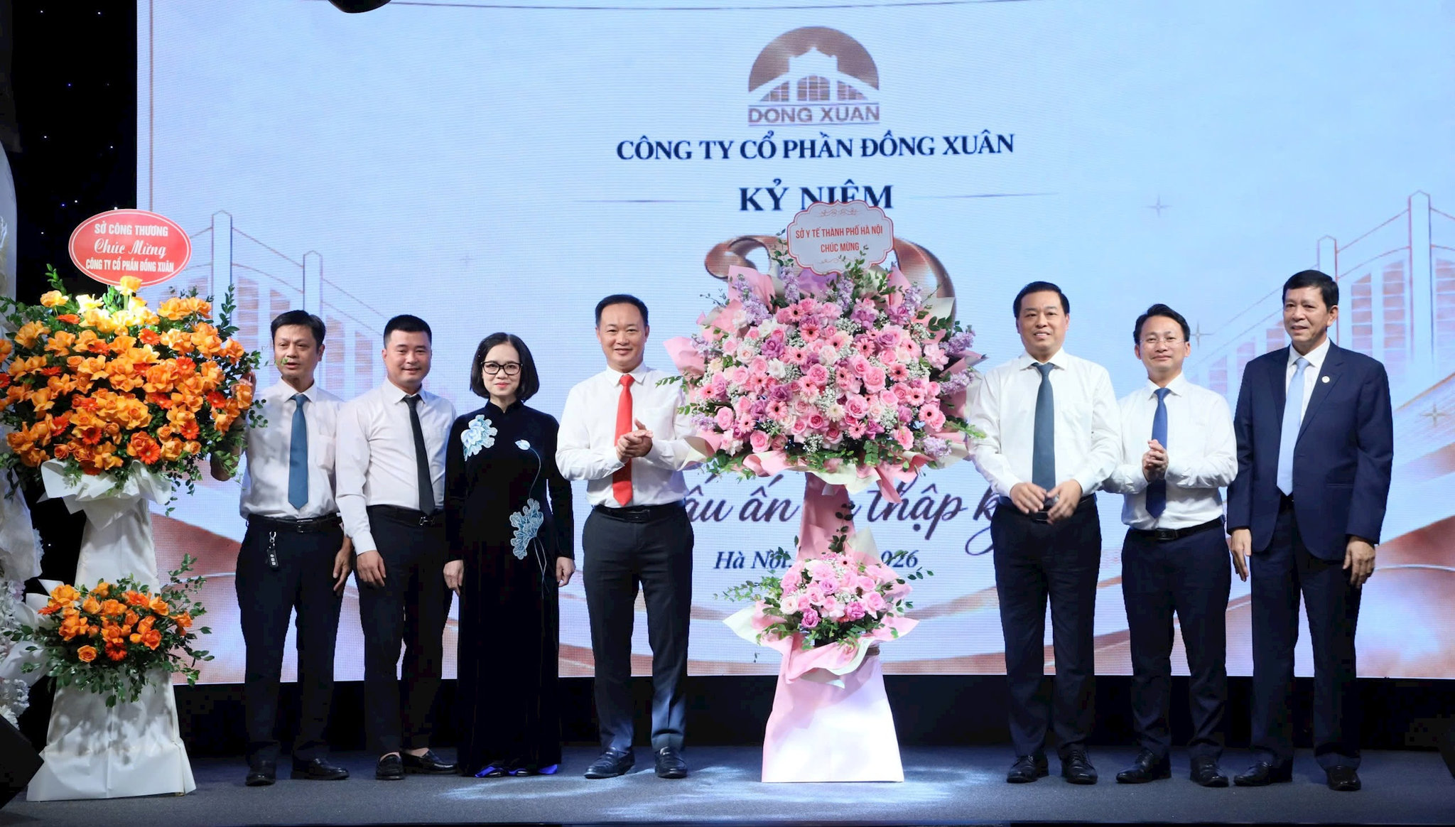 Lãnh đạo Công ty Cổ phần Đồng Xuân nhận lẵng hoa chúc mừng của các sở, ngành thành phố Hà Nội. Ảnh: PV