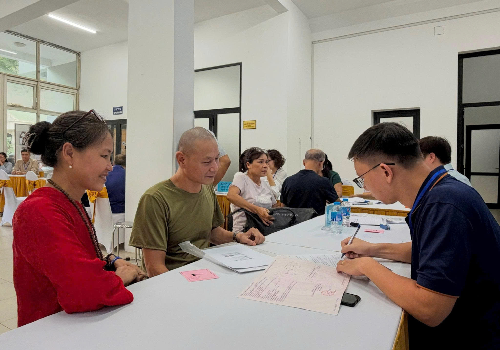 Lực lượng chức năng phường Kim Liên hỗ trợ người dân làm thủ tục nhận chi trả tiền giải phóng mặt bằng. Ảnh: Nguyên Bảo