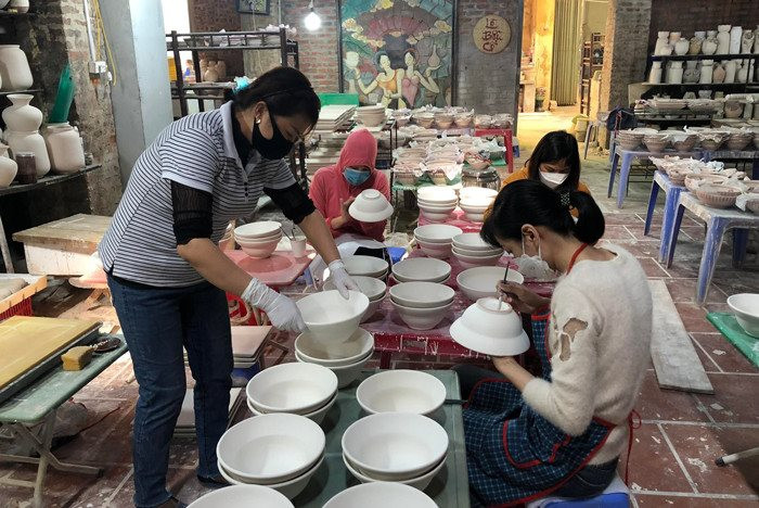 Những người thợ tại làng gốm Bát Tràng miệt mài hoàn thiện sản phẩm thủ công qua từng công đoạn. Ảnh: PV