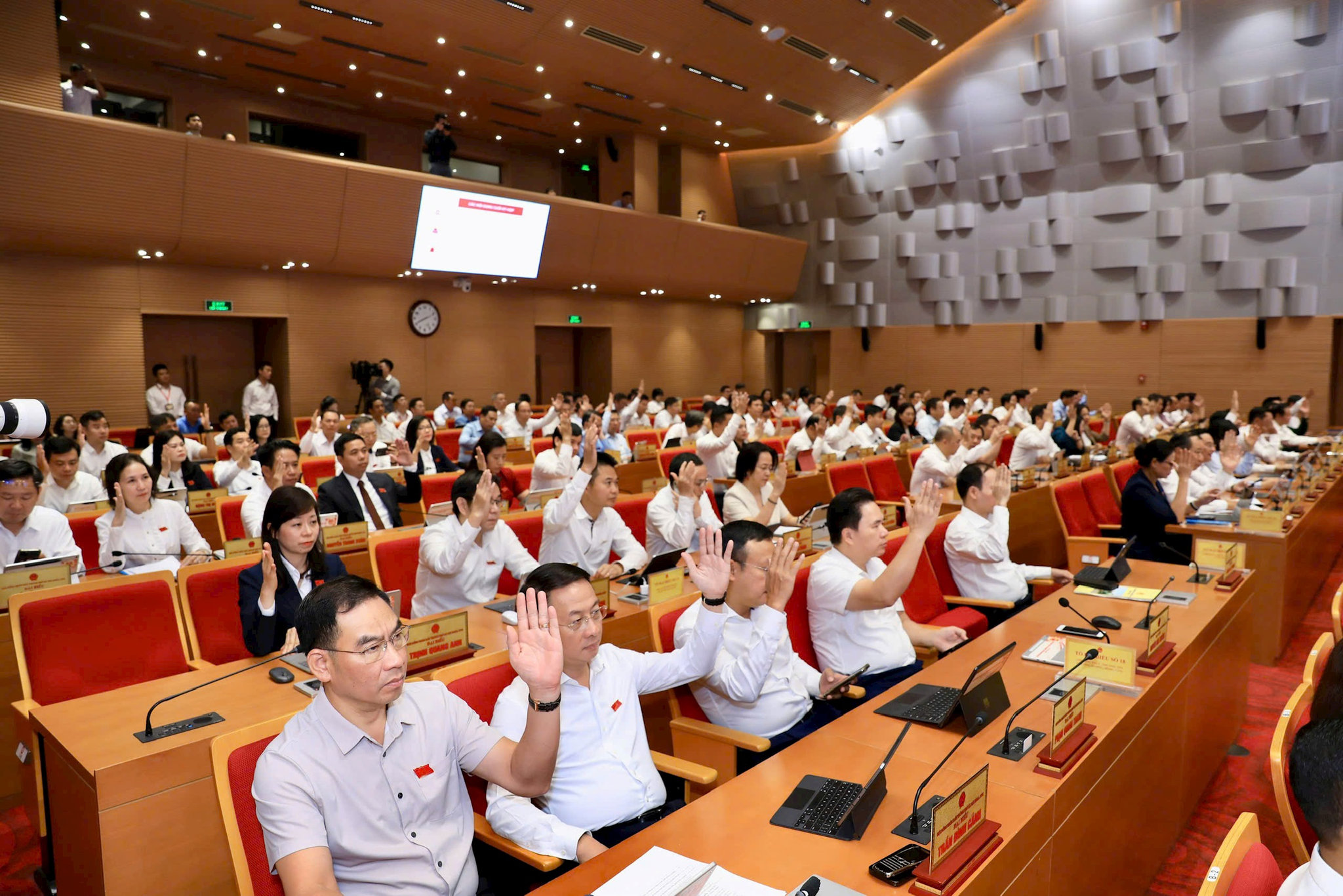 Đại biểu HĐND thành phố biểu quyết thông qua chương trình kỳ họp. Ảnh: Thành Thái Hùng