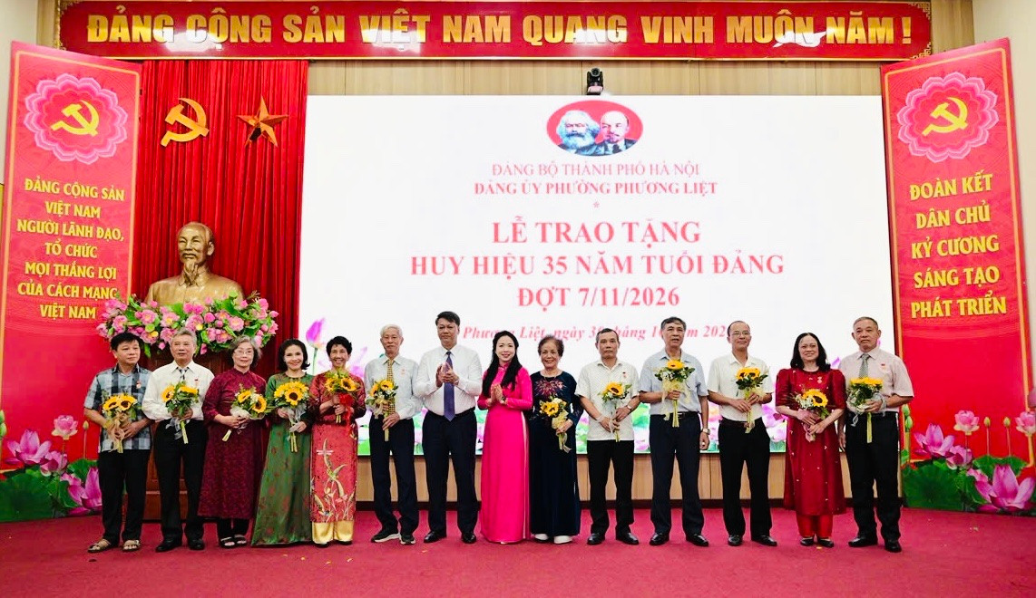 Bí thư Đảng uỷ, Chủ tịch HĐND phường Phương Liệt Nguyễn Minh Tiến và Phó Bí thư Thường trực Đảng uỷ phường Bùi Thu Trang trao Huy hiệu 35 năm tuổi Đảng cho các đảng viên. Ảnh: QH