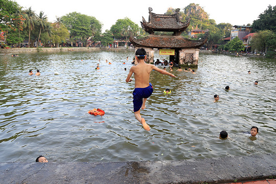 Trẻ em Hà Nội tắm giải nhiệt ngày nắng nóng dưới hồ nghìn năm tuổi