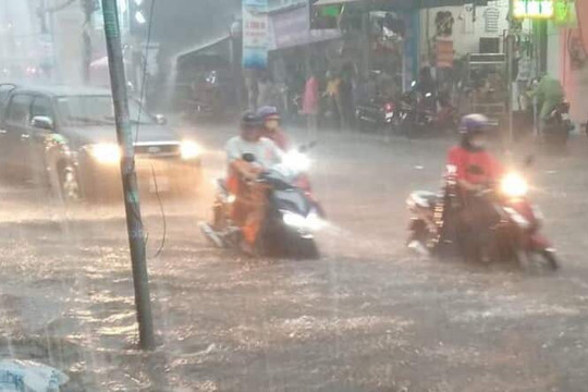 Mưa lớn, nước chảy xiết như suối trên đường TP Hồ Chí Minh, cuốn trôi cả người và xe máy