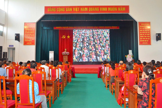 Cán bộ và nhân dân phường Tùng Thiện theo dõi diễu binh, diễu hành qua màn hình led