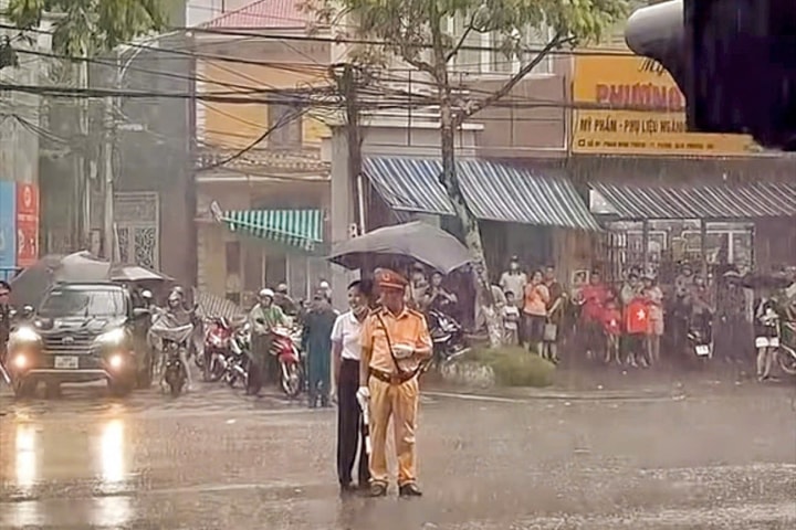 Người phụ nữ che ô cho CSGT dầm mưa, khoảnh khắc lay động triệu trái tim