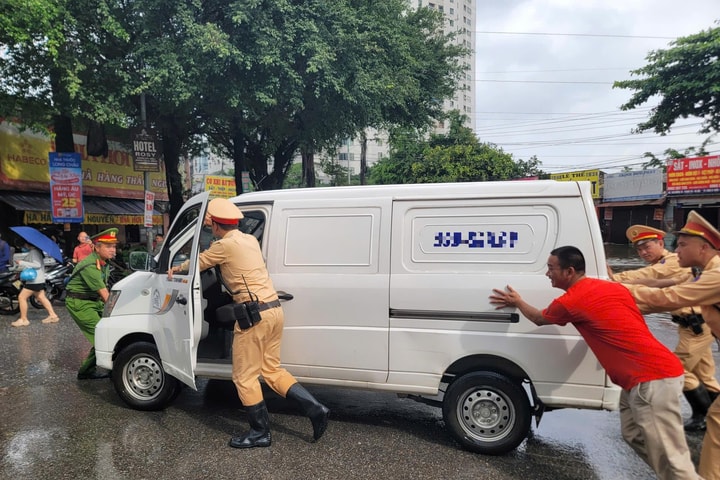 Cảnh sát giao thông Hà Nội hỗ trợ người dân di chuyển qua điểm ngập